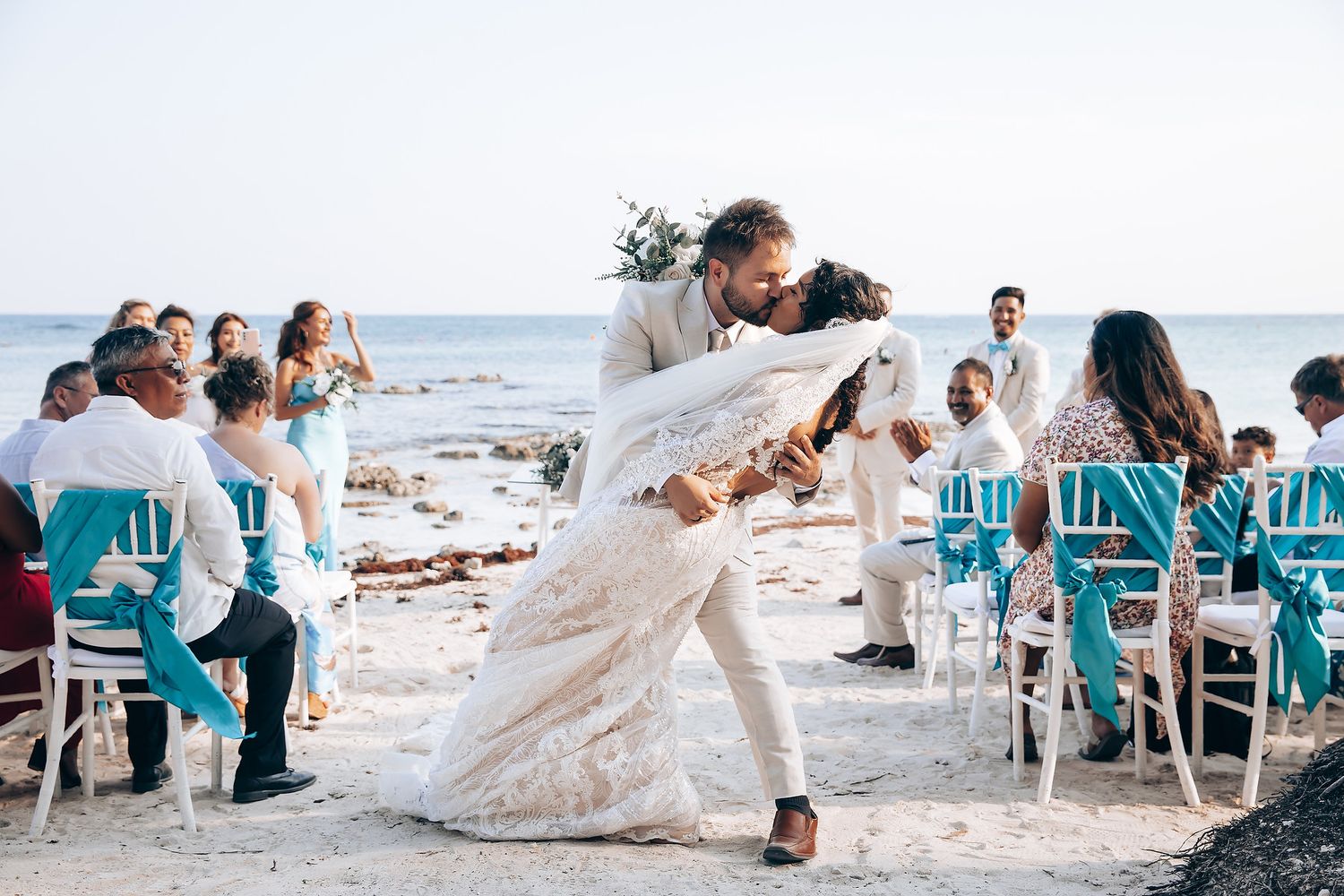 A collection of beach wedding photos showing guests in turquoise attire celebrating on a sunny shoreline.