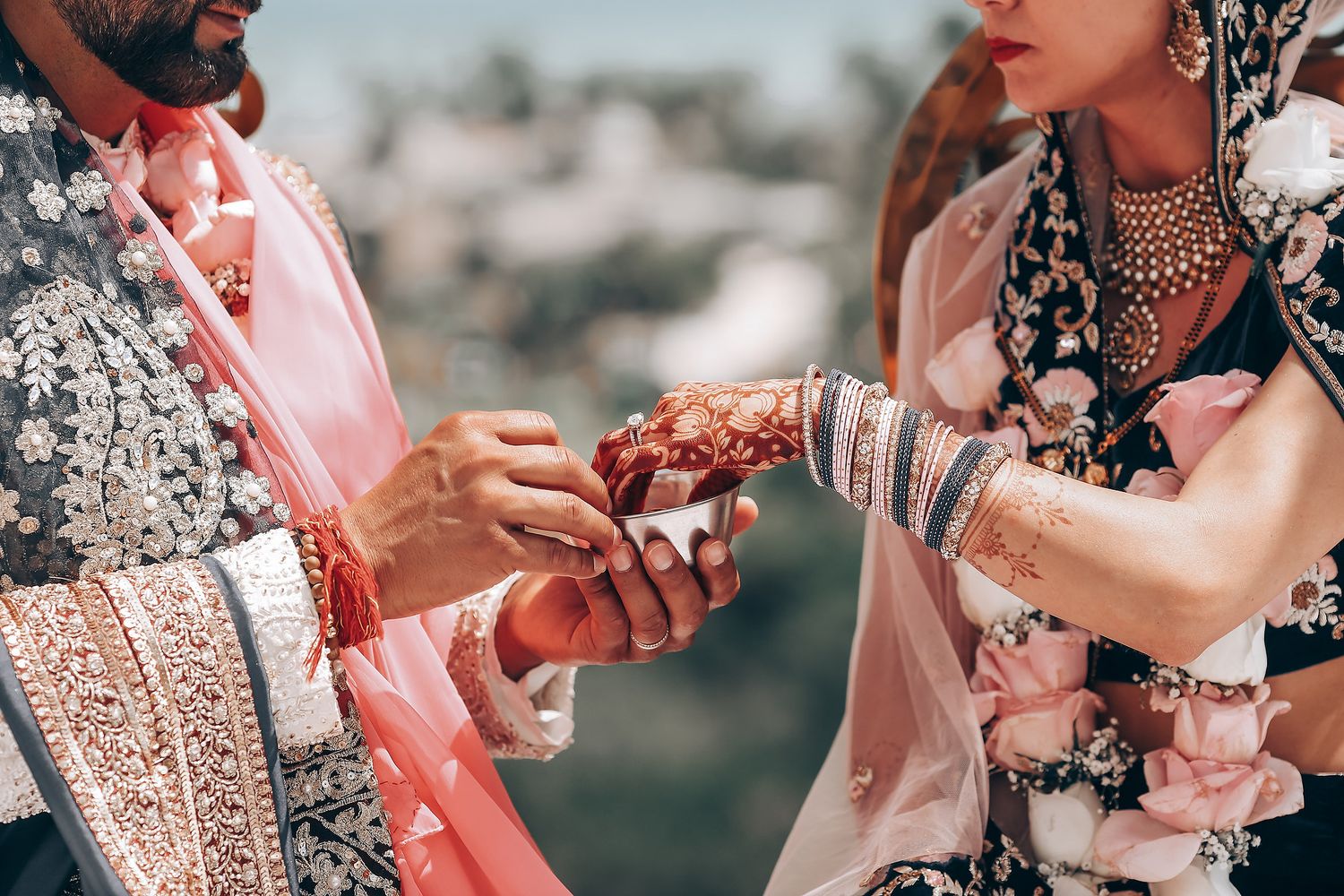 Close-up shot of traditional Indian bridal mehndi being applied to hands in intricate patterns and designs.