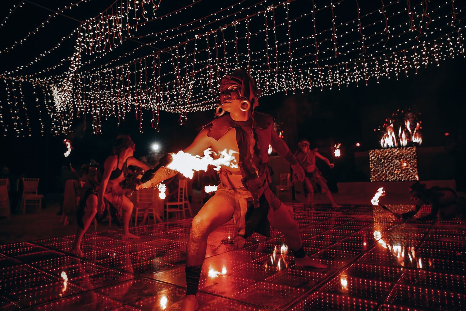 String lights illuminate a dark outdoor venue creating a magical nighttime ambiance at a special event.