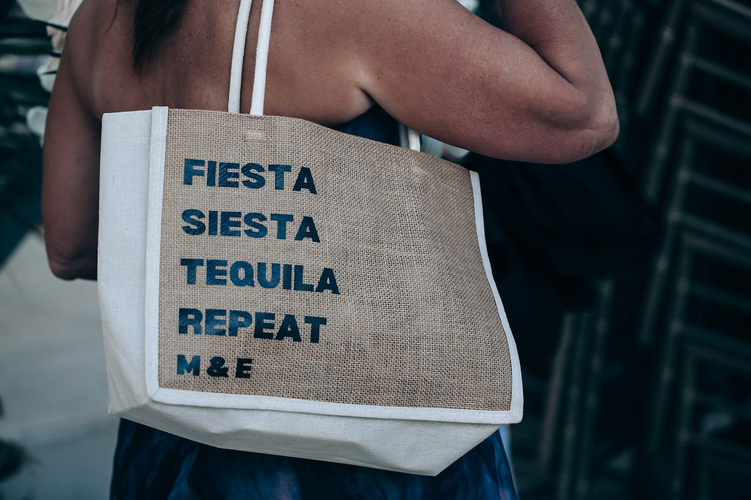A collection of canvas tote bags with text reading 'Fiesta Siesta Tequila Repeat' displayed in a retail setting.