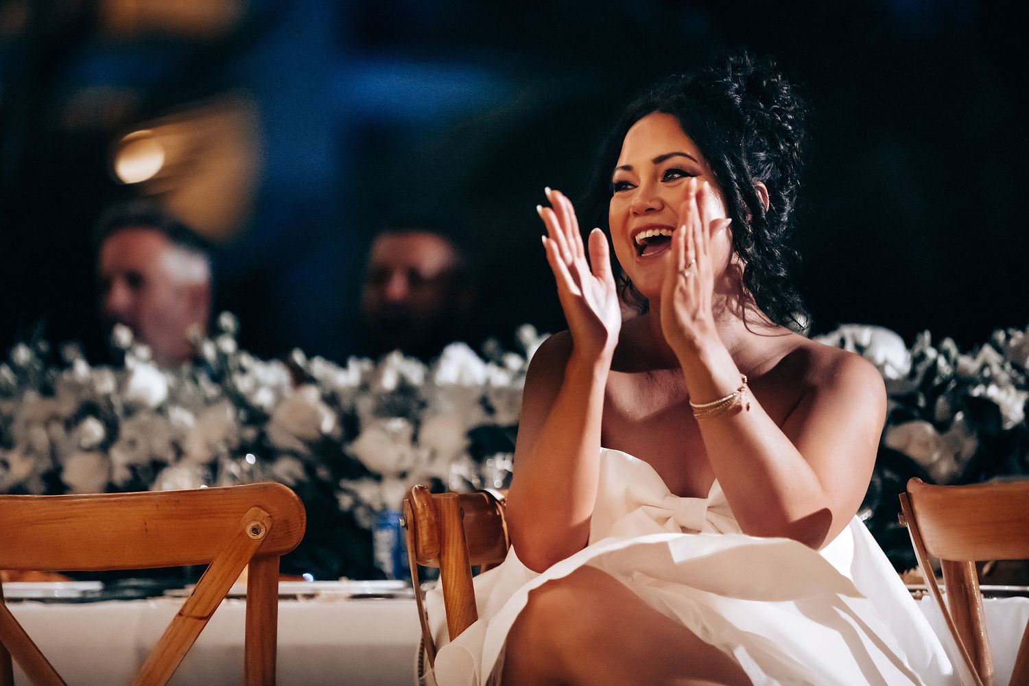 Candid reception moments captured showing joyful laughter and celebrations at an evening wedding event.