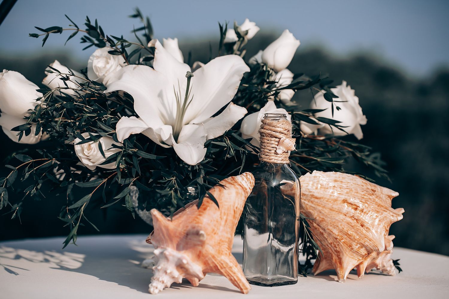 Seashells and starfish decorations arranged on a light colored surface with floral elements.