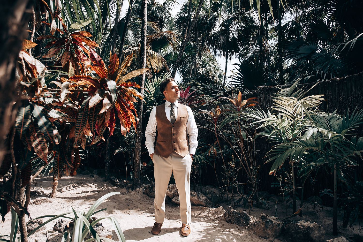 Wedding attire photo in tropical garden setting with palm trees.