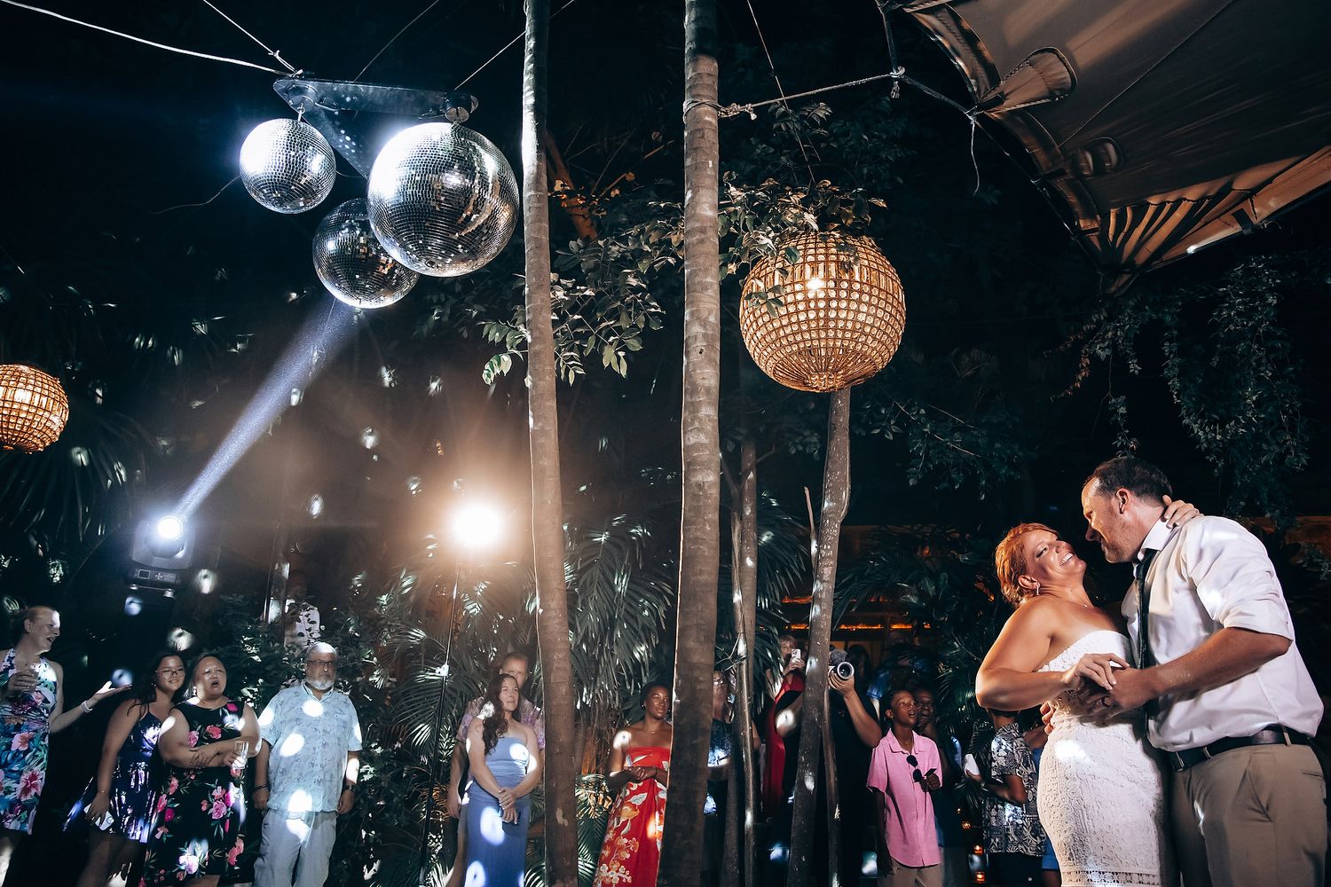 Wedding celebration with disco balls and dramatic lighting creating a festive atmosphere.