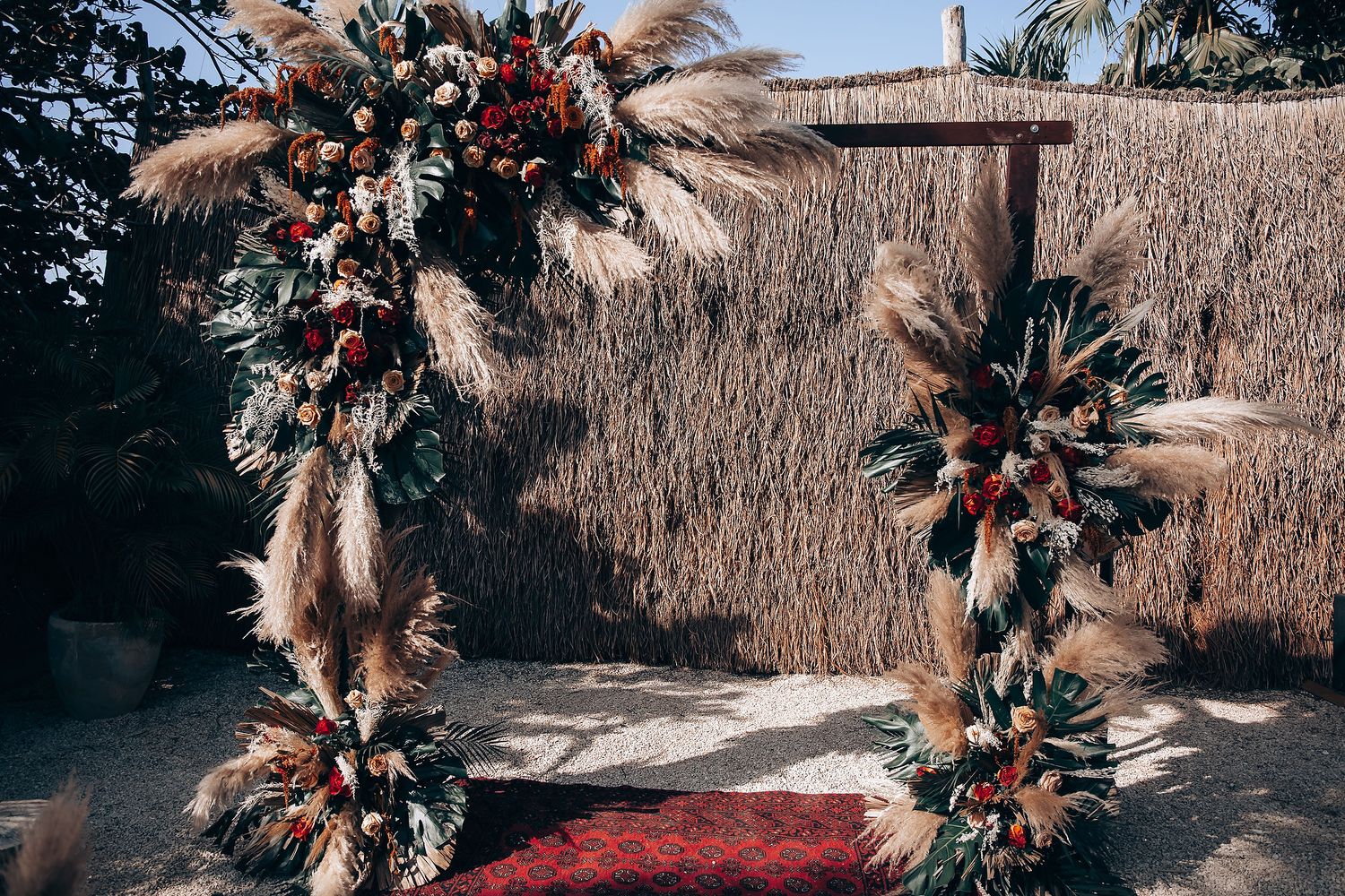 Tropical wedding setting with dried palm fronds and natural decor elements.