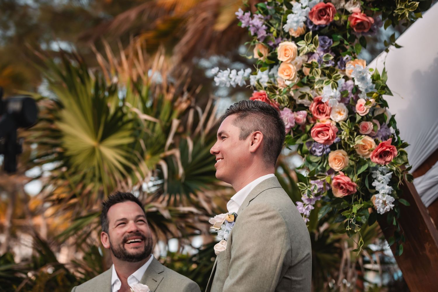 Outdoor wedding ceremony with floral arrangements and wooden architectural elements.