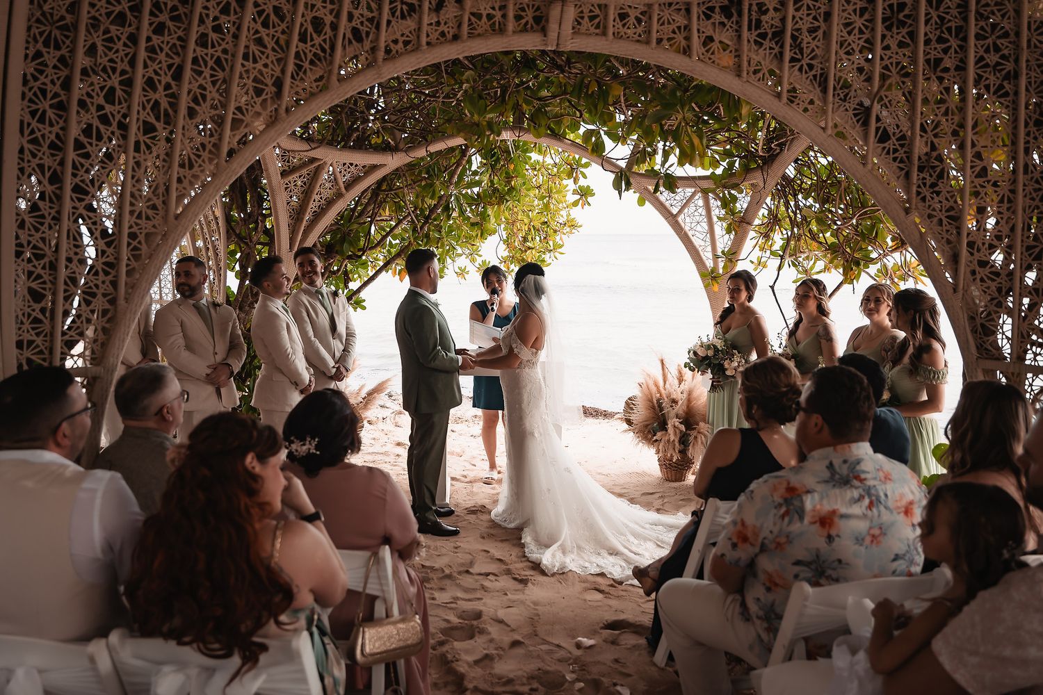 Panoramic view of wedding guests mingling under an elegant outdoor pavilion.
