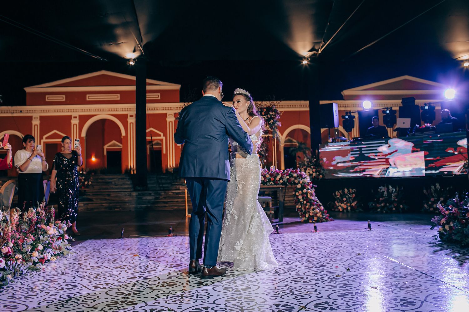 Couples dancing on an illuminated purple dance floor during a wedding reception celebration.