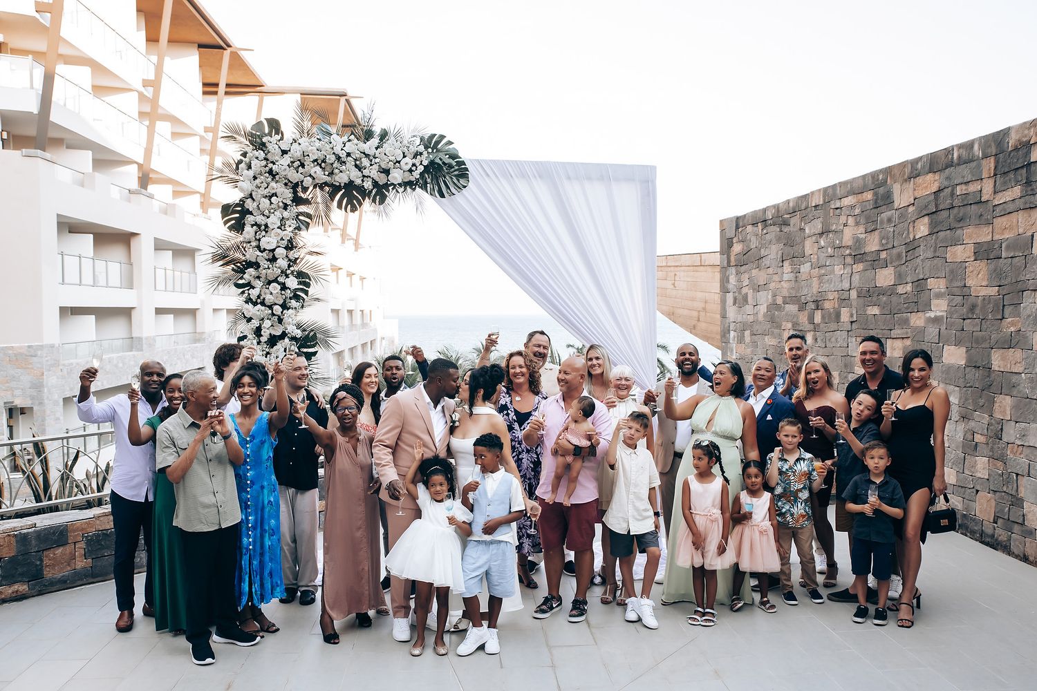 Wide angle view of wedding reception guests mingling on a scenic outdoor terrace.