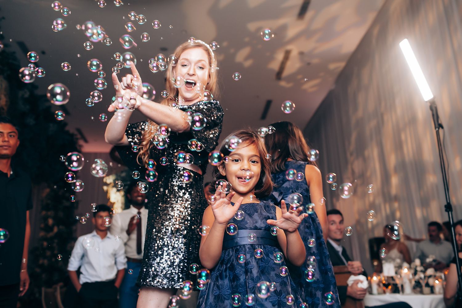 Joyful celebration with soap bubbles floating through the air at a wedding reception.