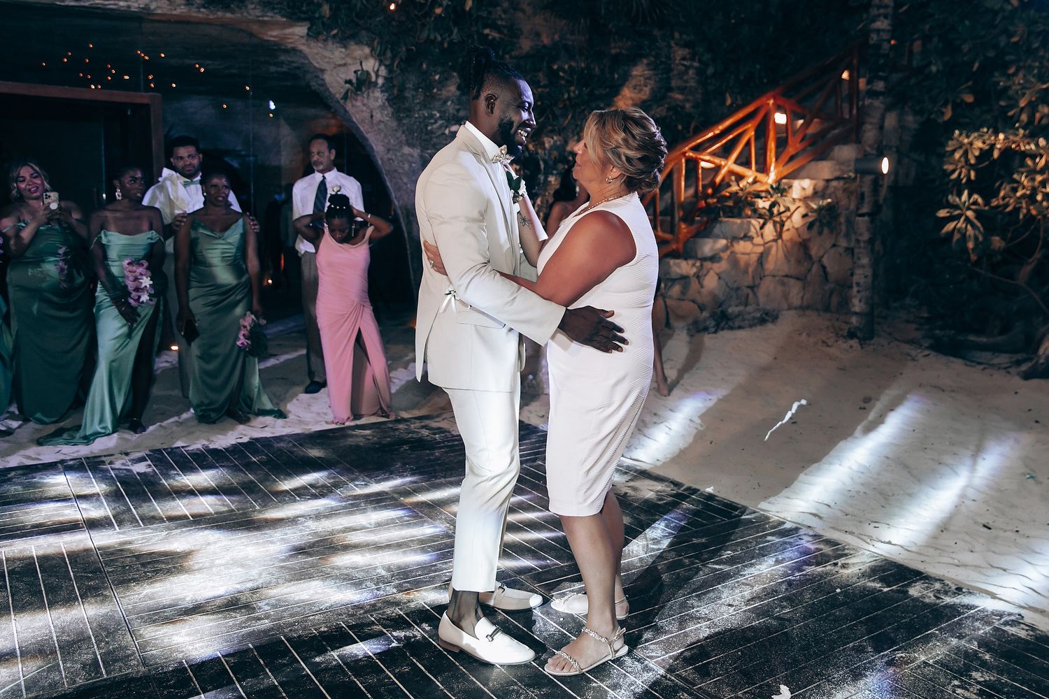 Couple dancing together at a nighttime reception with light effects.