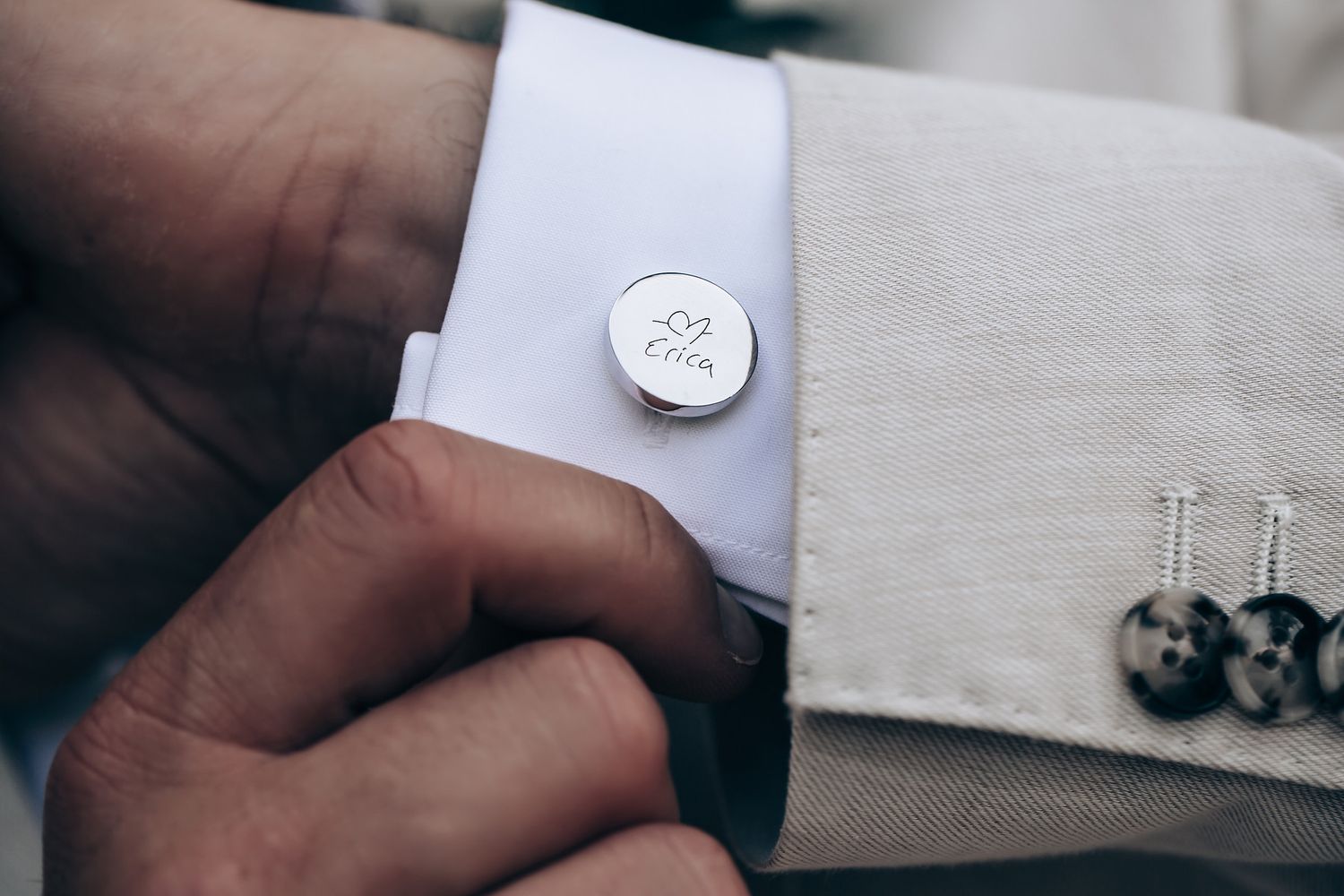Close-up details of wedding preparations showing cufflinks and formal attire accessories.