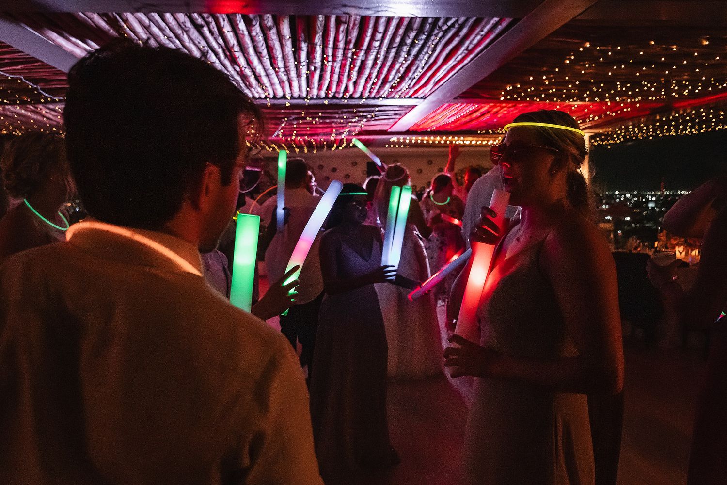 Dance floor illuminated with purple and pink lighting effects at a wedding reception.