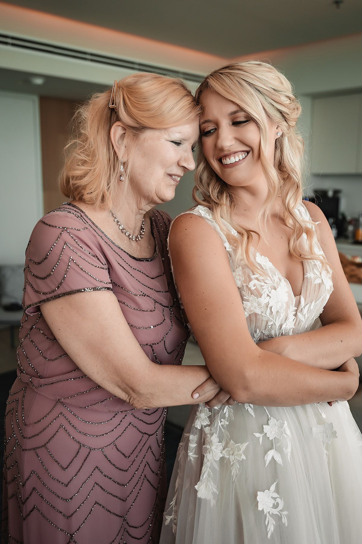 Two people in formal attire sharing an intimate moment and laughing together.