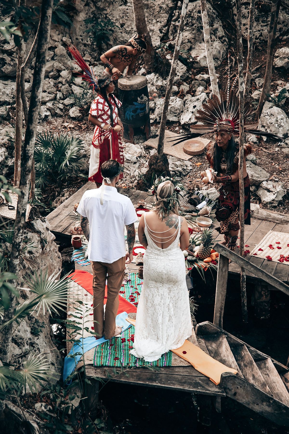 Wedding couple participates in ancient Mayan ritual ceremony at a sacred cenote in the jungle.