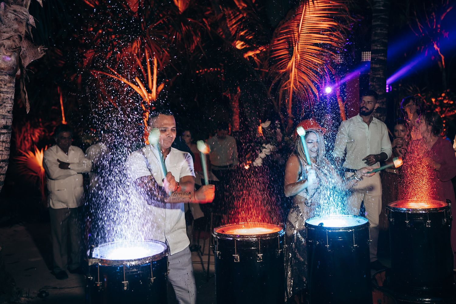 Dramatic fountain light show with blue and red illuminated water streams in a dark venue.