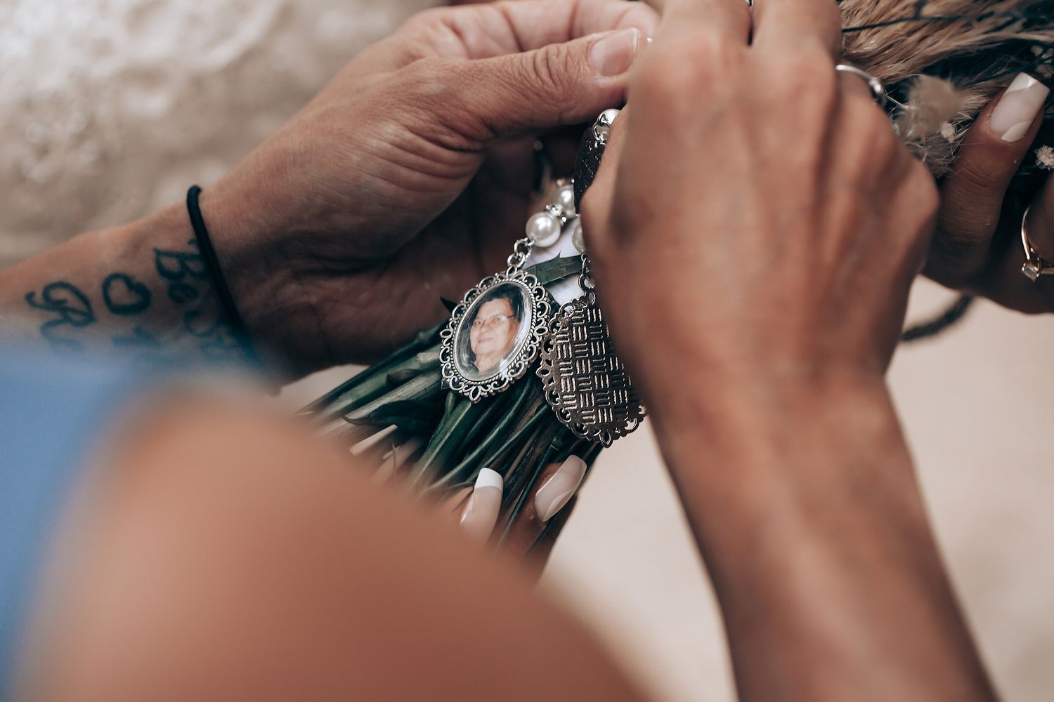 Close-up details of hands holding a book during an outdoor wedding ceremony.
