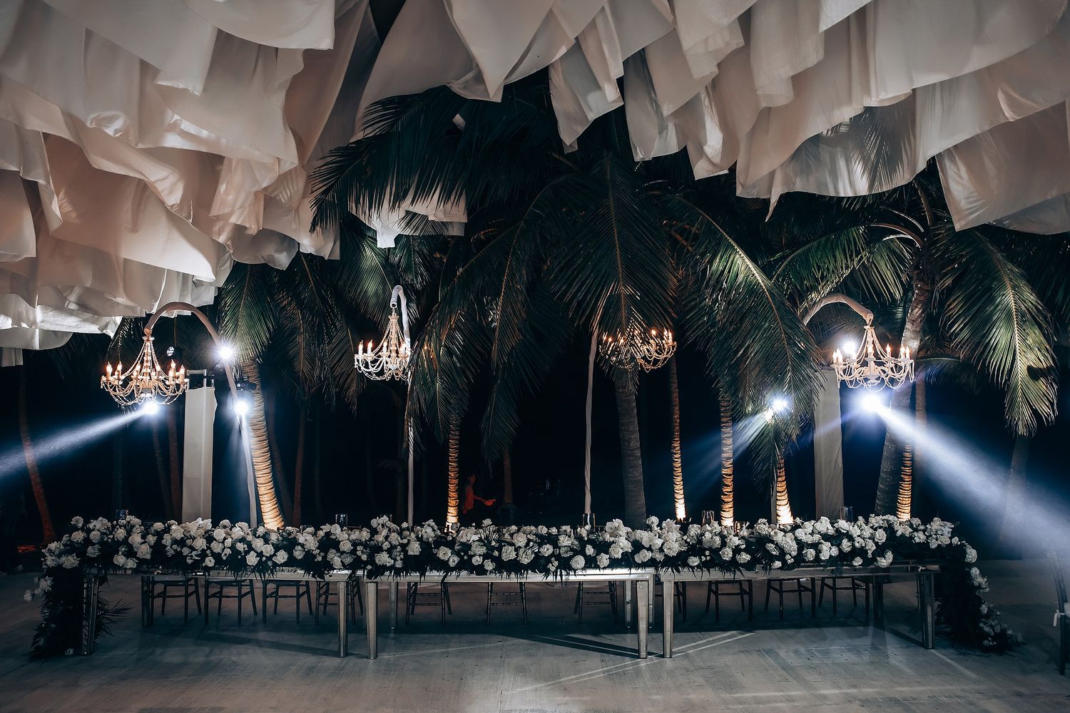 Elegant wedding reception venue with dramatic ceiling draping and chandeliers creating an ethereal atmosphere.