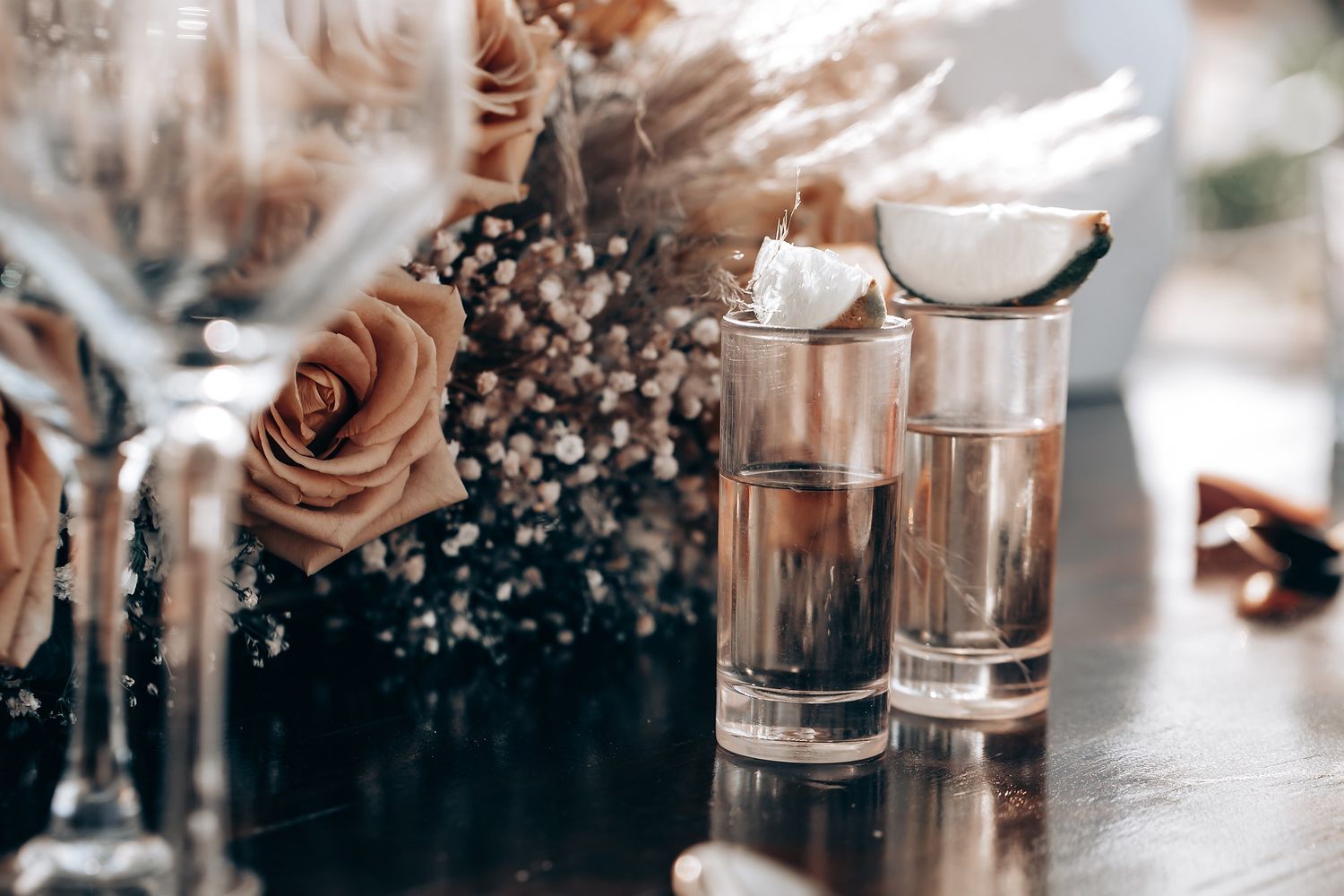 Close-up details of wedding reception glassware with soft bokeh lighting effects.