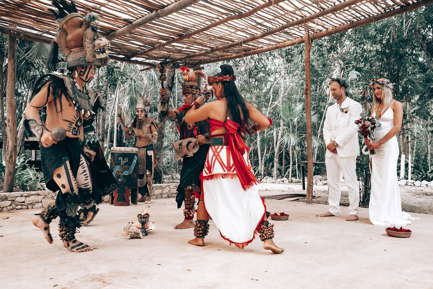Ceremonial Mayan dance performance with traditionally dressed dancers and observers in white.