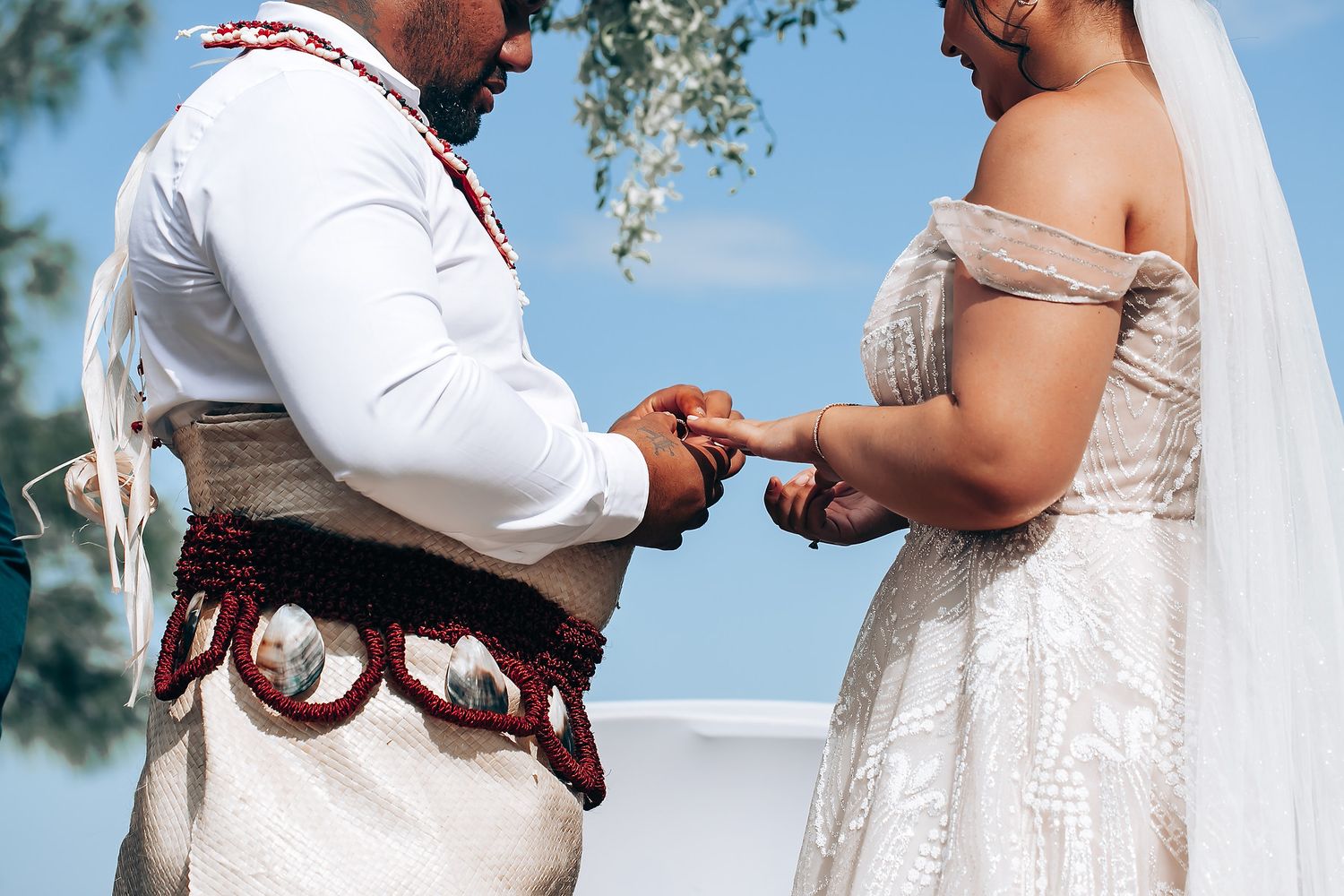 Intimate wedding ceremony moments captured under bright blue sky with palm trees.