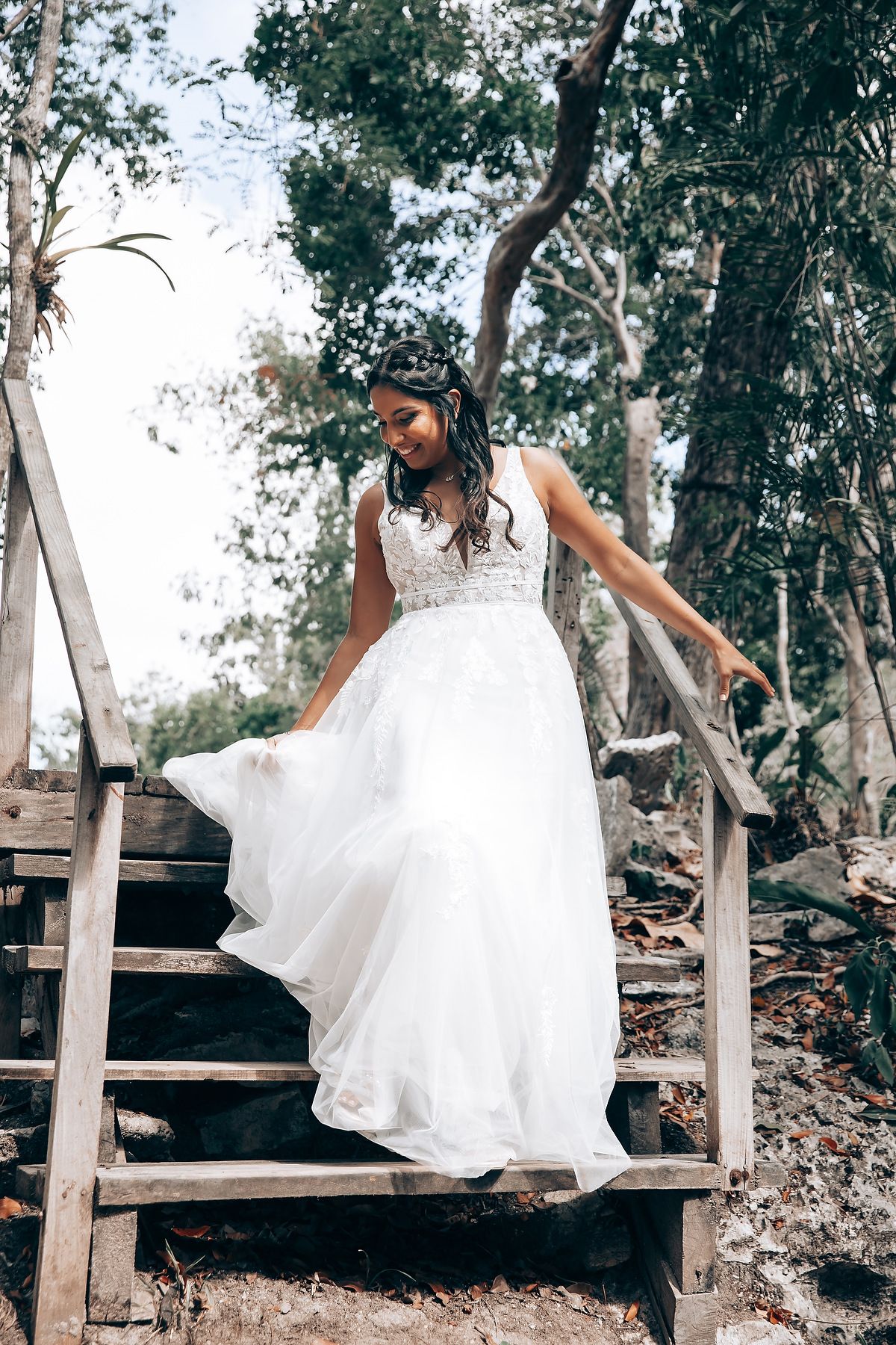 A series of photos showing someone in a flowing white wedding dress sitting and posing on rustic wooden steps outdoors.