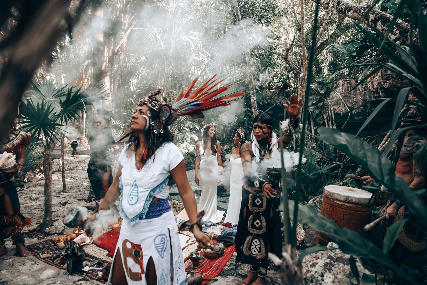 Traditional ceremony in a forest setting with smoke and cultural elements.
