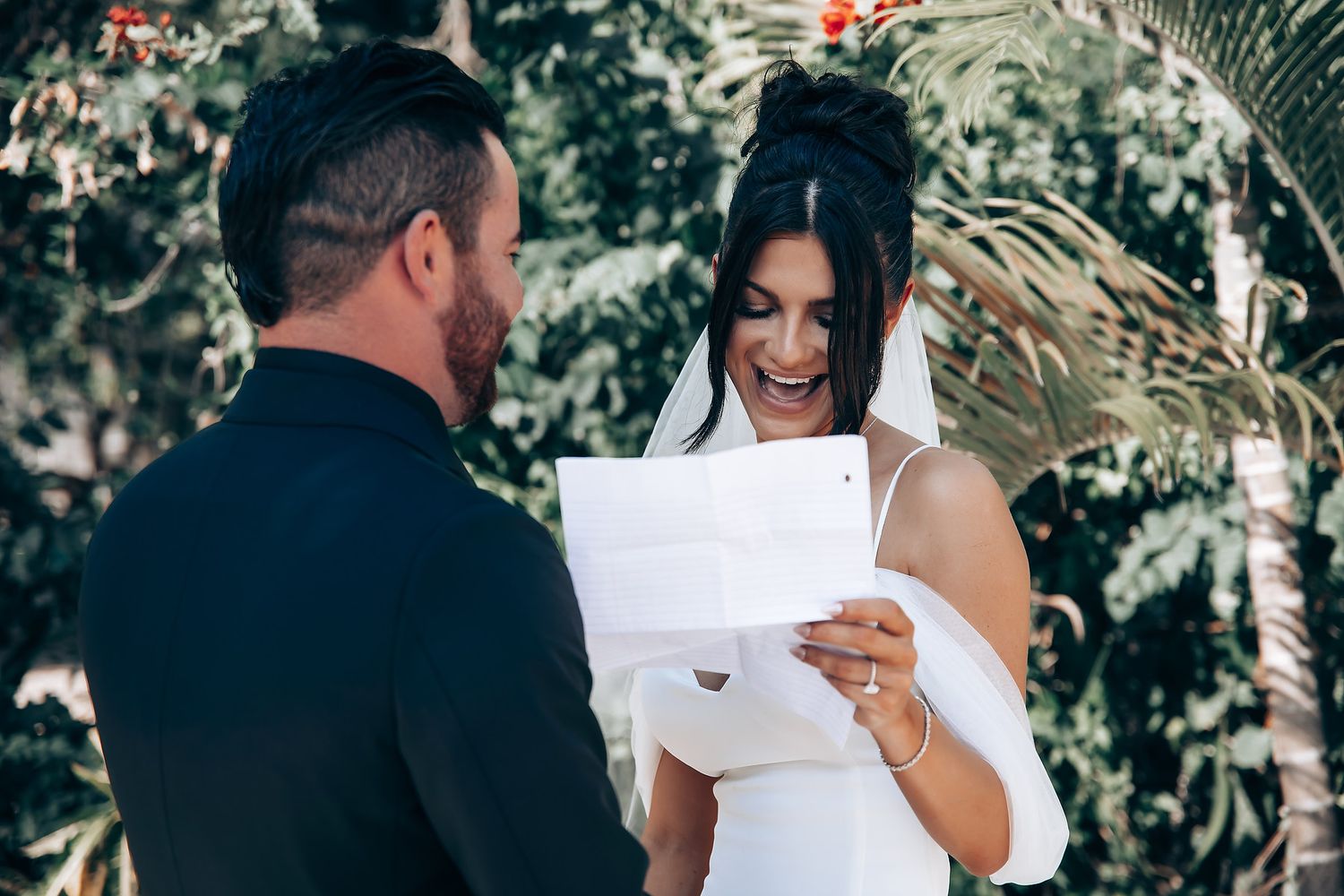 Emotional first look reaction between couple surrounded by tropical foliage.
