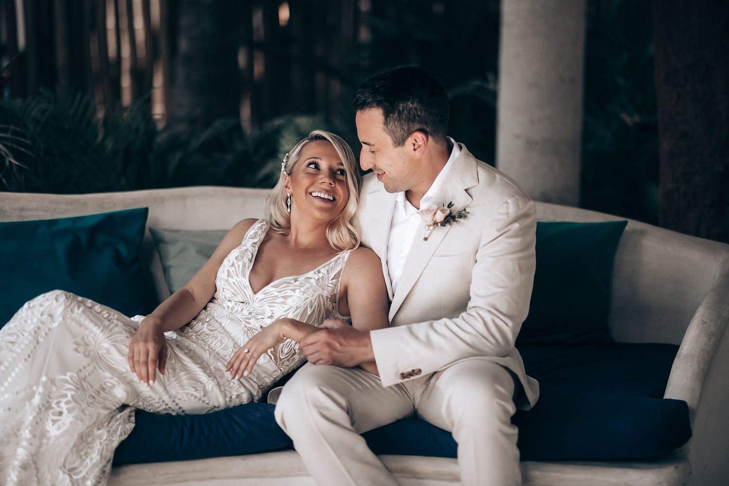 Romantic wedding couple shares intimate moments on a luxurious couch during their special day.