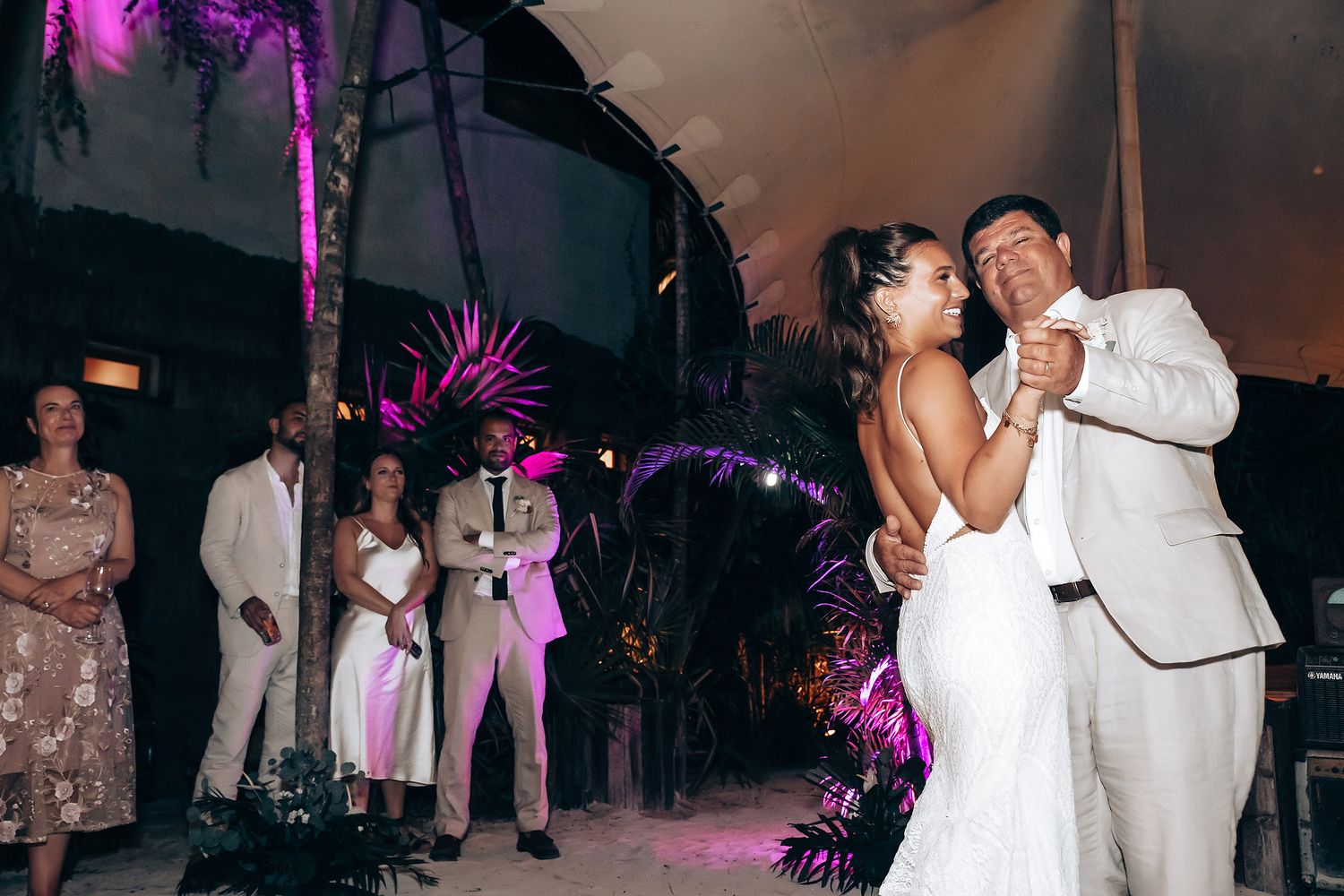 Wedding reception dance floor illuminated with purple lighting and festive atmosphere.