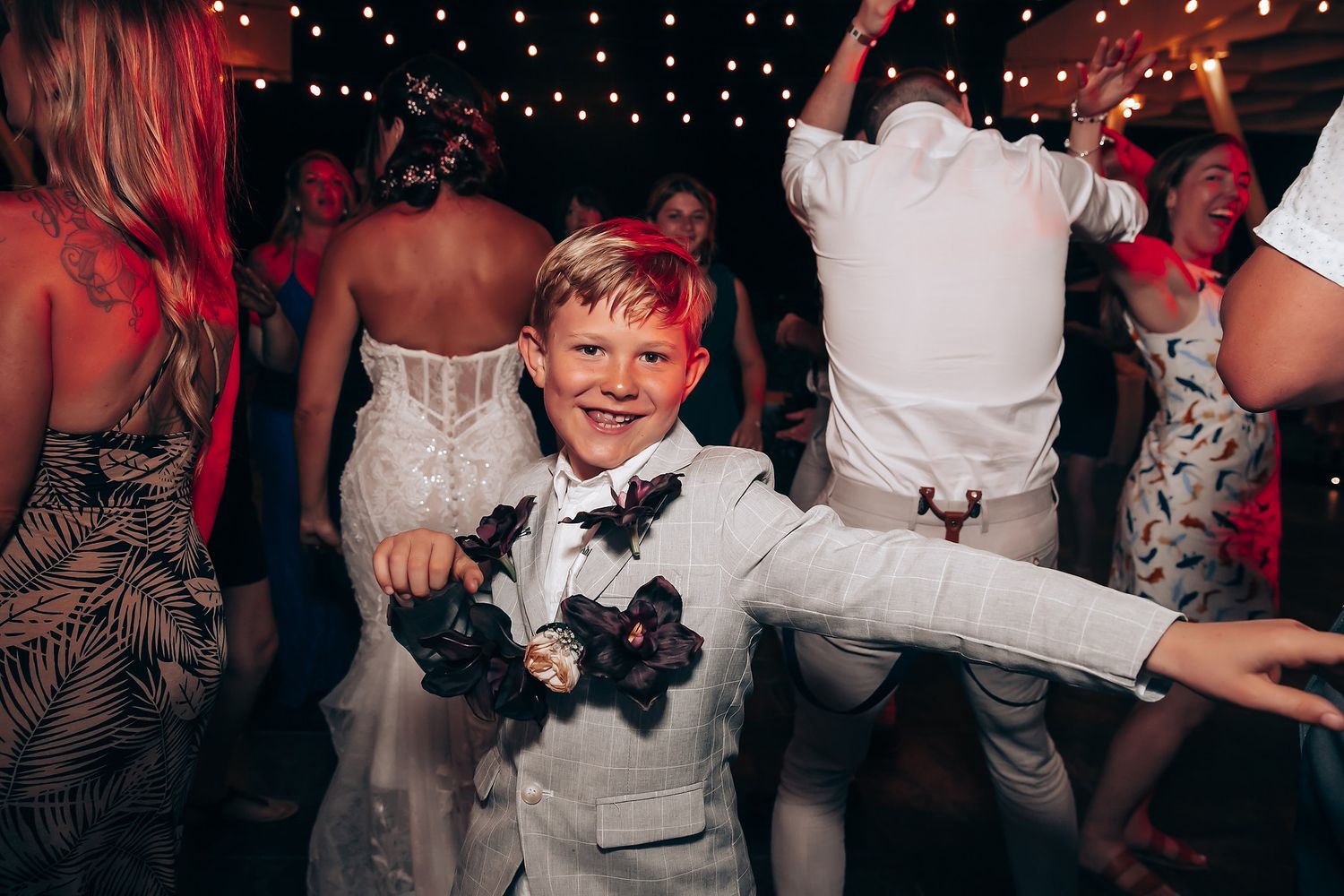 Wedding reception dance party with twinkling lights and red ambient lighting.