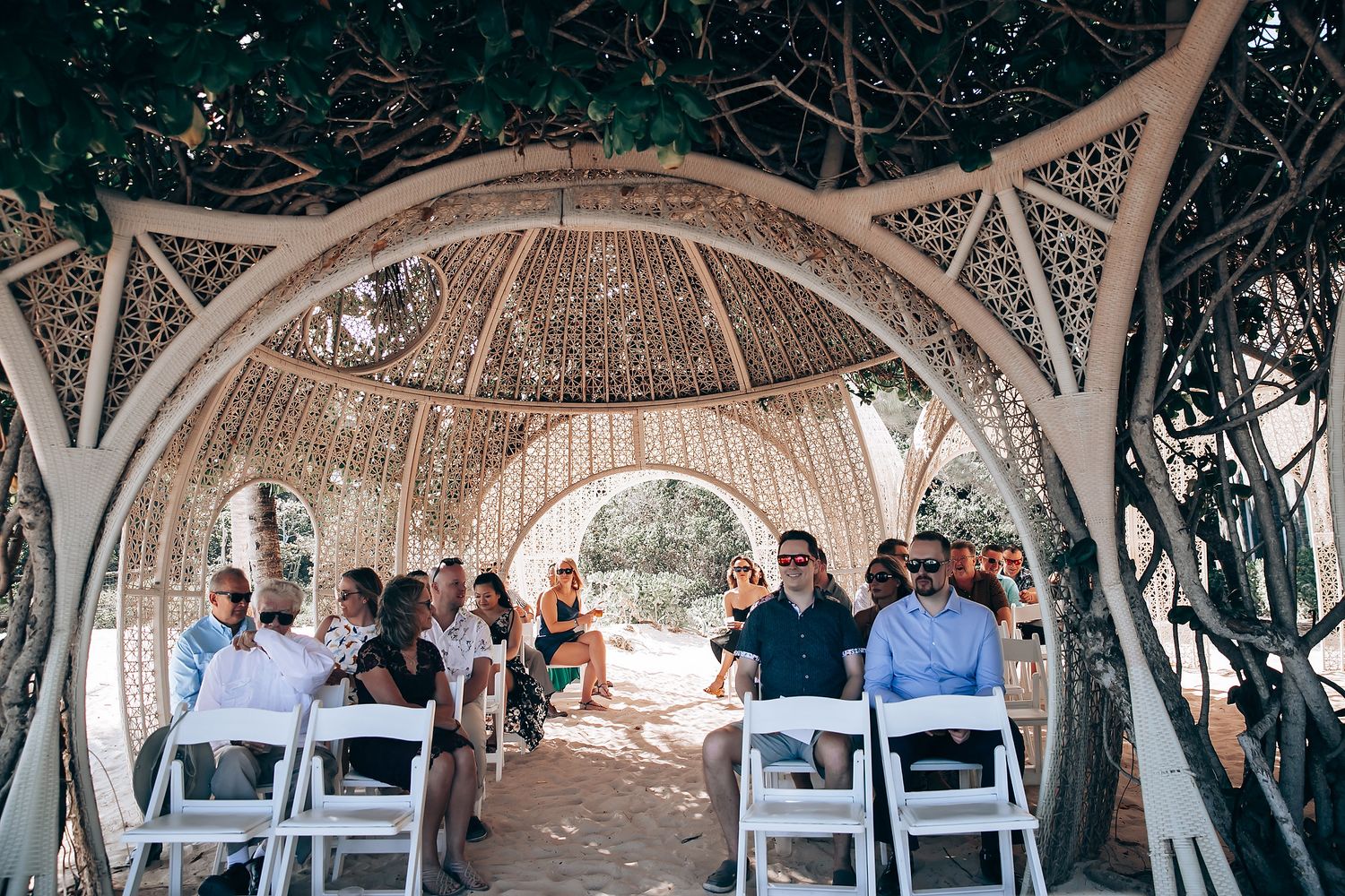 Wide view of wedding ceremony setup under latticed dome structure.
