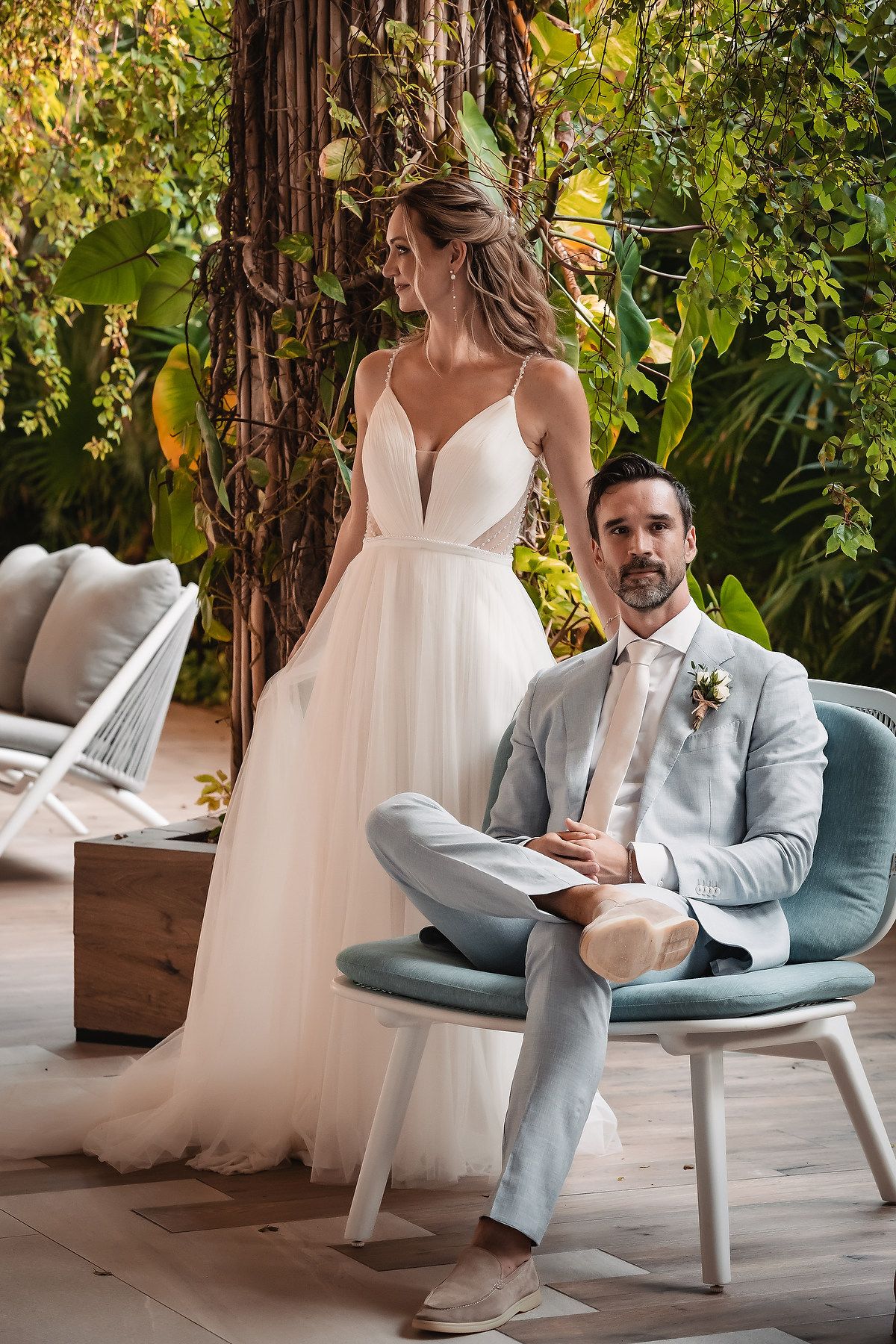 A couple shares a quiet moment on modern outdoor furniture surrounded by lush greenery.
