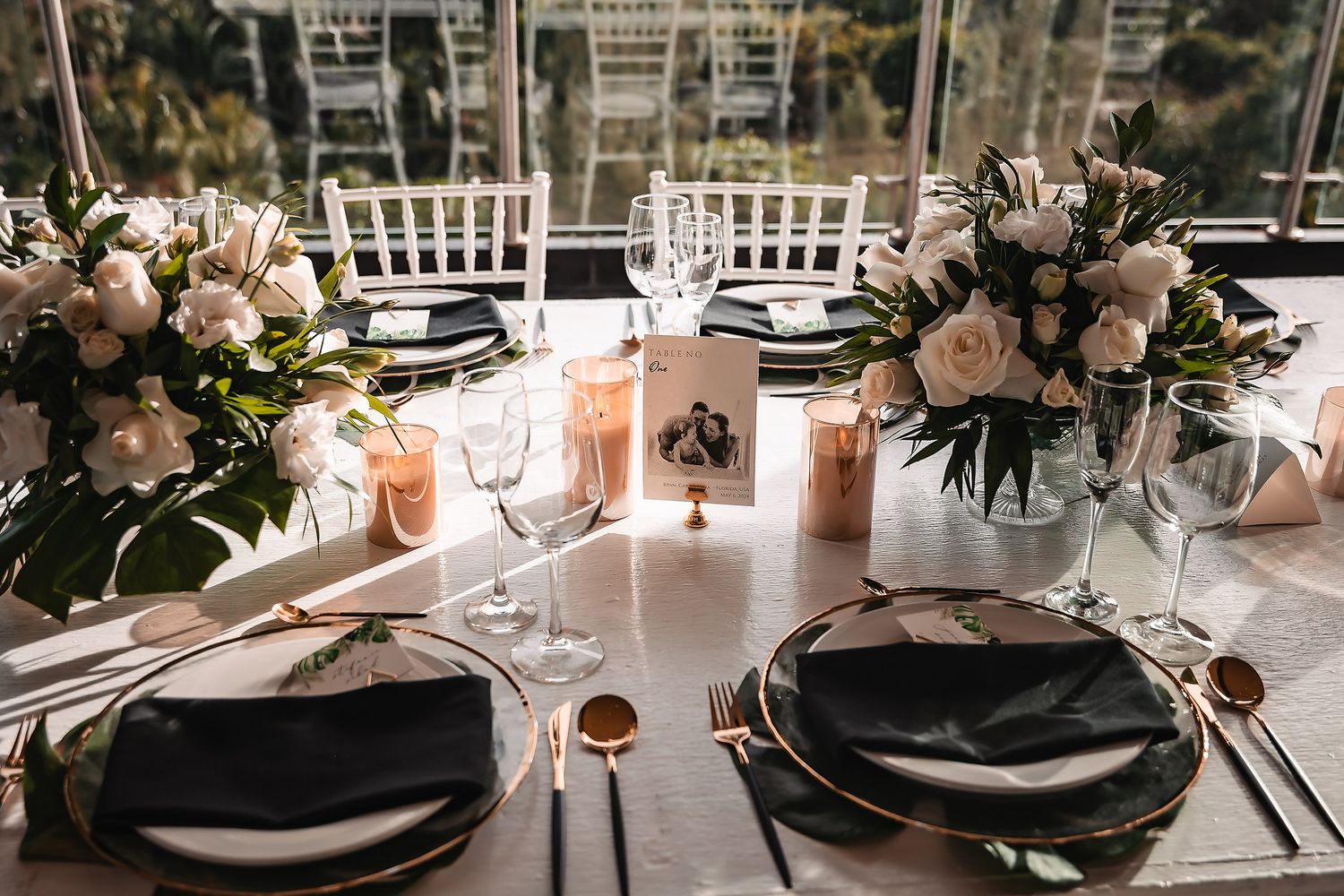 Modern wedding table settings with black charger plates and floral centerpieces.