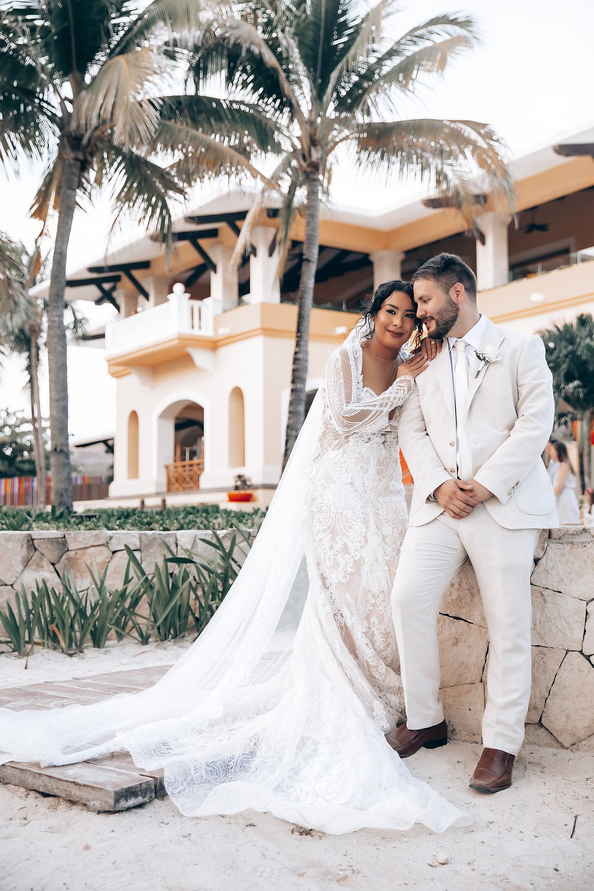 Elegant destination wedding photos against Spanish-style architecture and tropical palm trees.