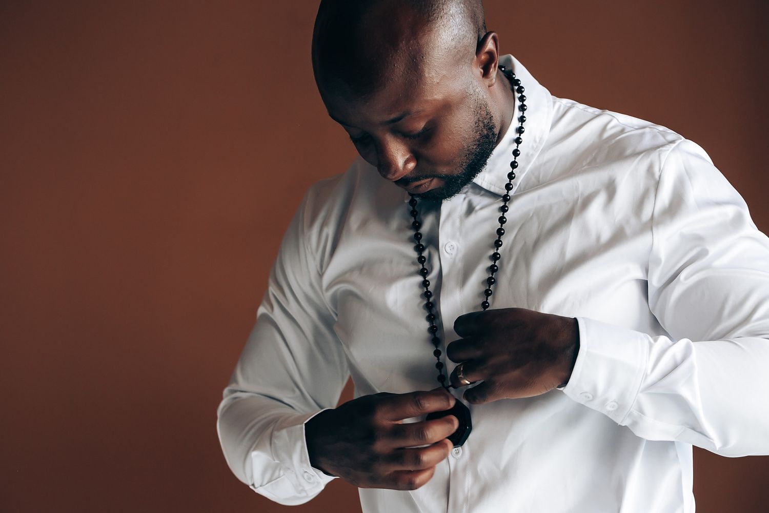 A collage of photos showing someone in a white button-down shirt adjusting their tie against a dark background.