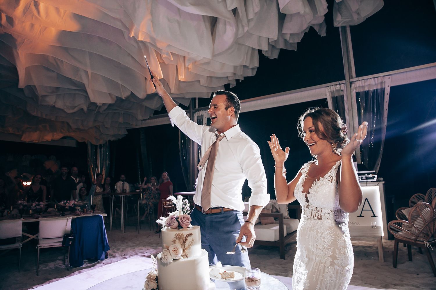 Wedding reception dance floor scene with white paper decorations and dramatic lighting.
