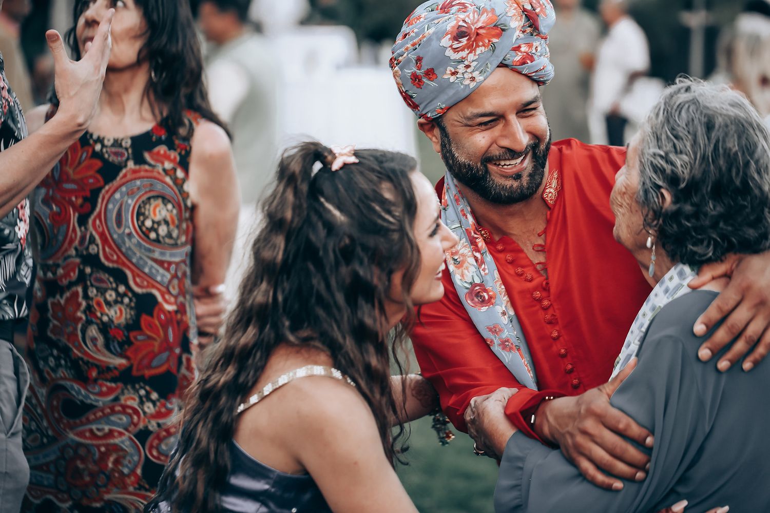 A joyful group of people dancing and celebrating together at an outdoor gathering.