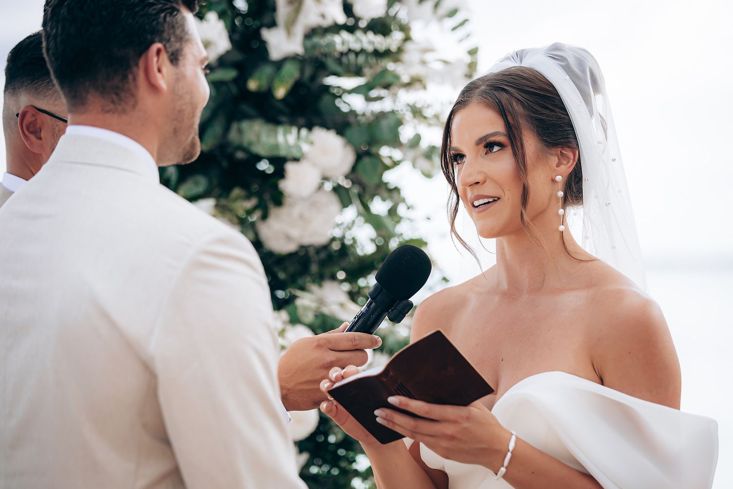 Elegant outdoor wedding ceremony setup with white floral arrangements and natural decor against a scenic backdrop.
