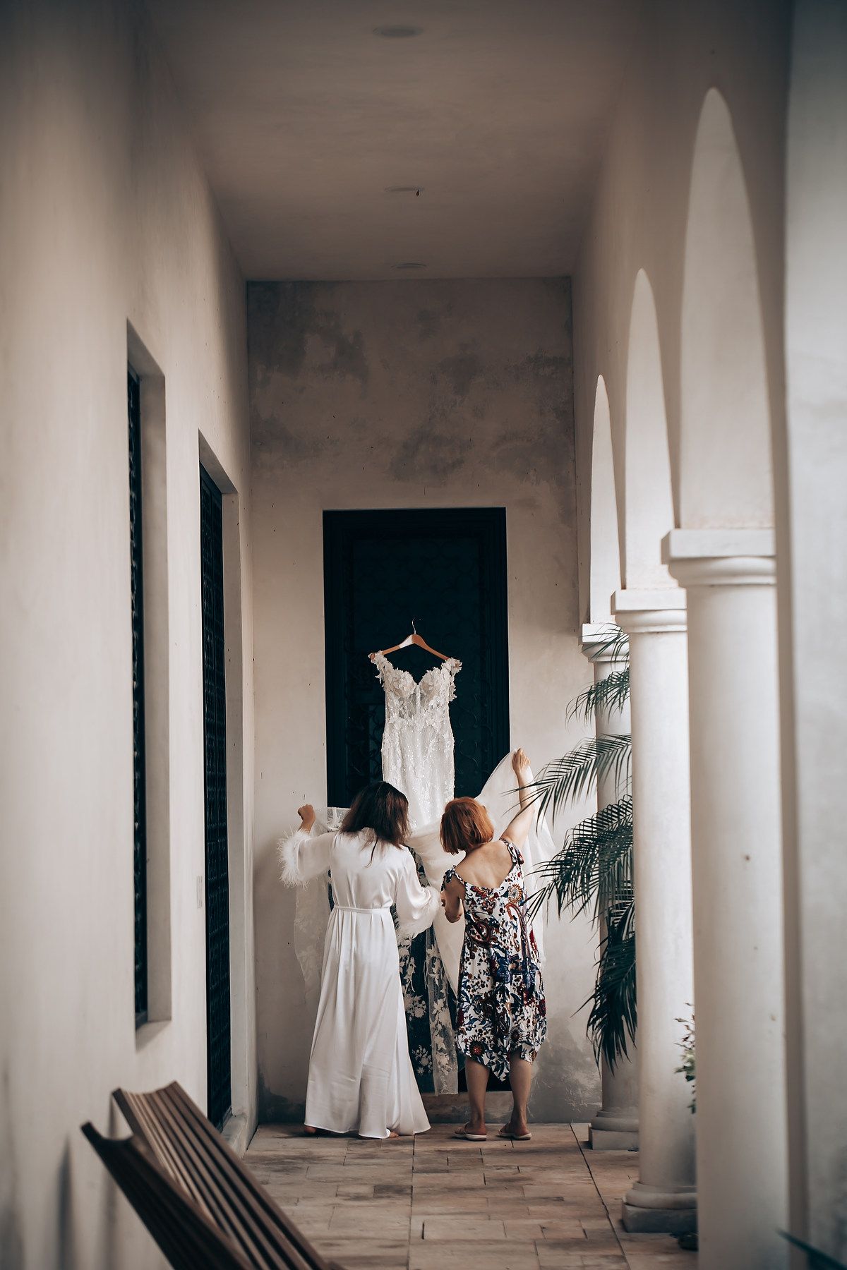 A sequence of monochromatic photos showing people walking through a bright white colonnade hallway.