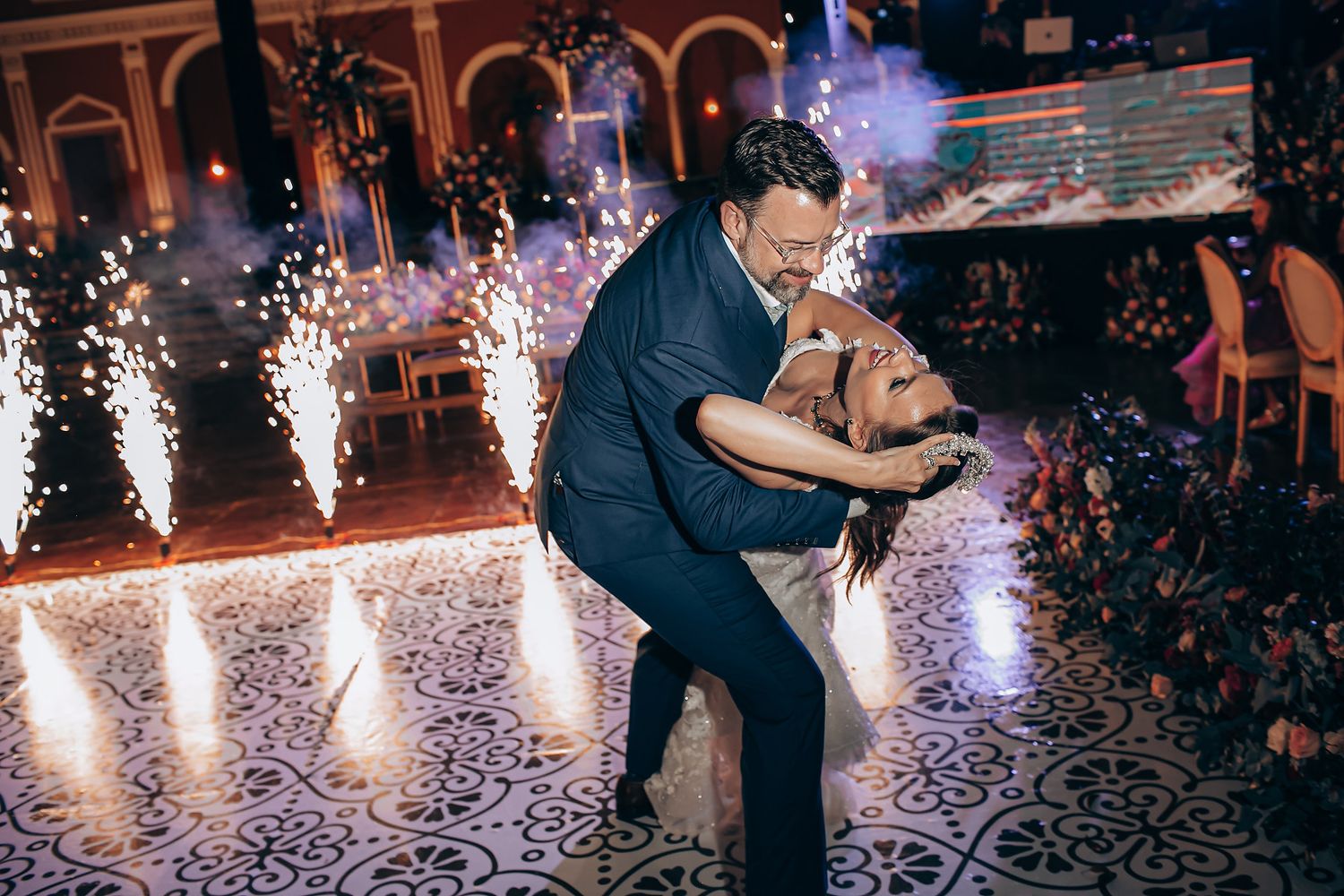 A romantic first dance at a wedding reception with sparklers creating a magical atmosphere on the dance floor.