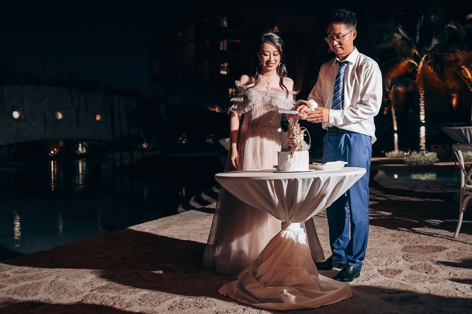 Outdoor wedding reception setup with elegant table arrangements and soft evening lighting.