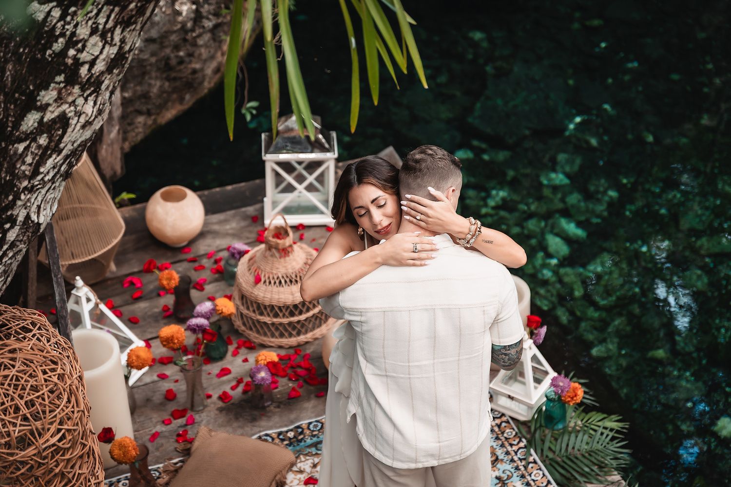 Romantic couple embracing in an outdoor garden setting with decorative lanterns and rose petals.