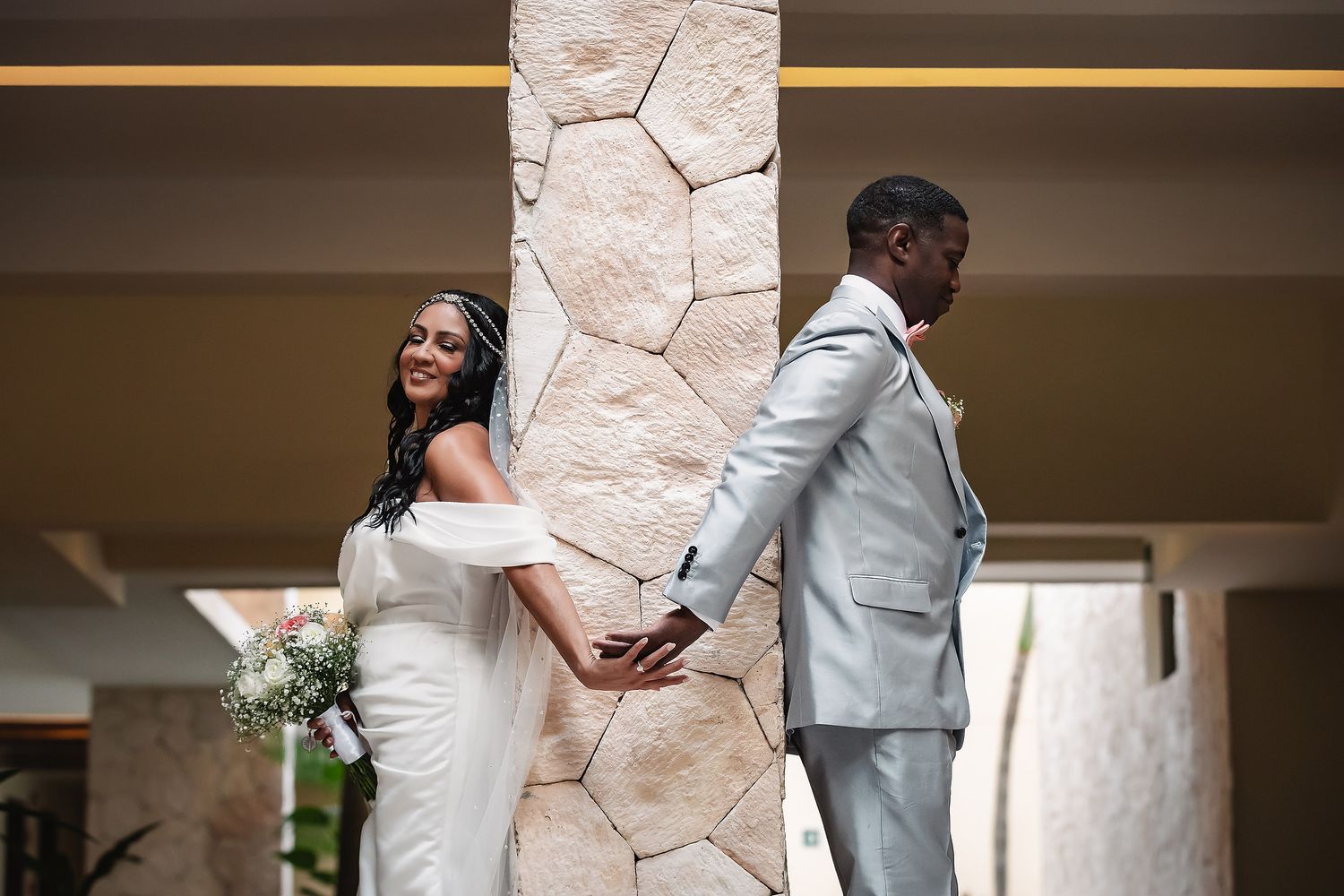 Wedding ceremony setup with elegant white decor and floral arrangements in an indoor venue.
