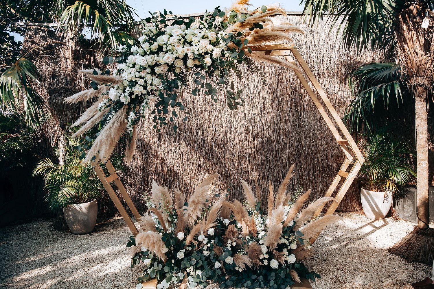 Tropical wedding venue with palm trees and decorative floral arrangements creating a romantic atmosphere.