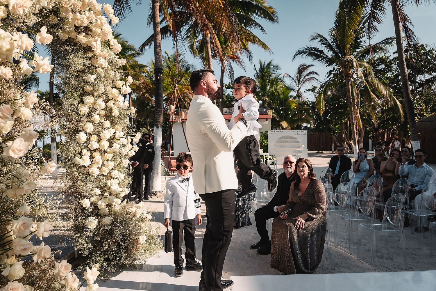 Candid moments between wedding guests at a beachfront ceremony.