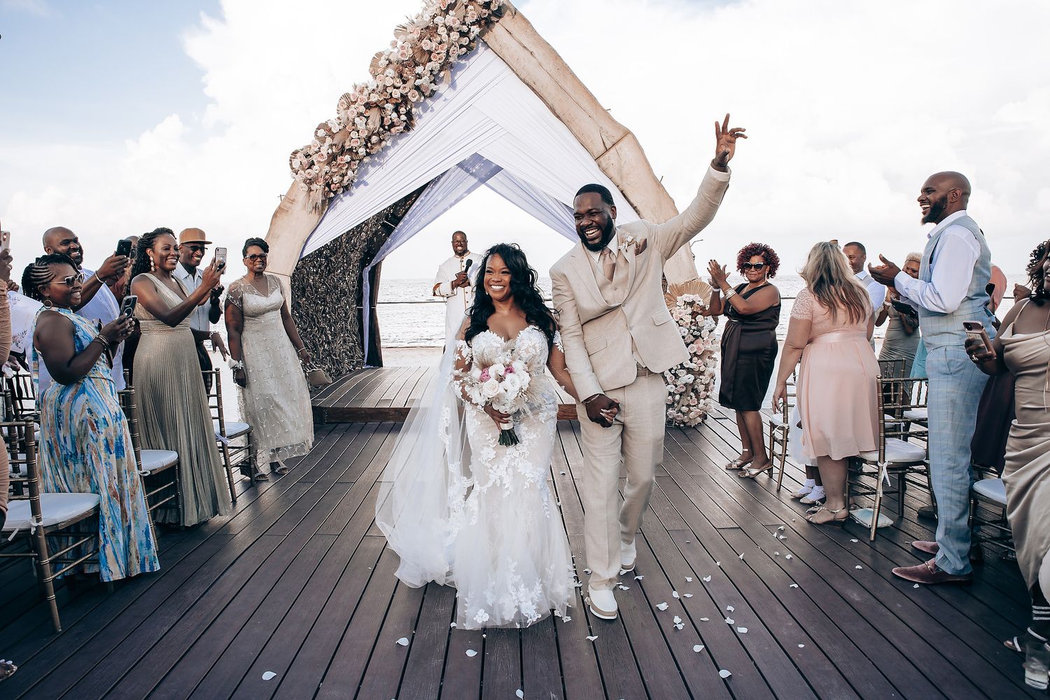 Wedding guests celebrating on a wooden deck during an outdoor reception.