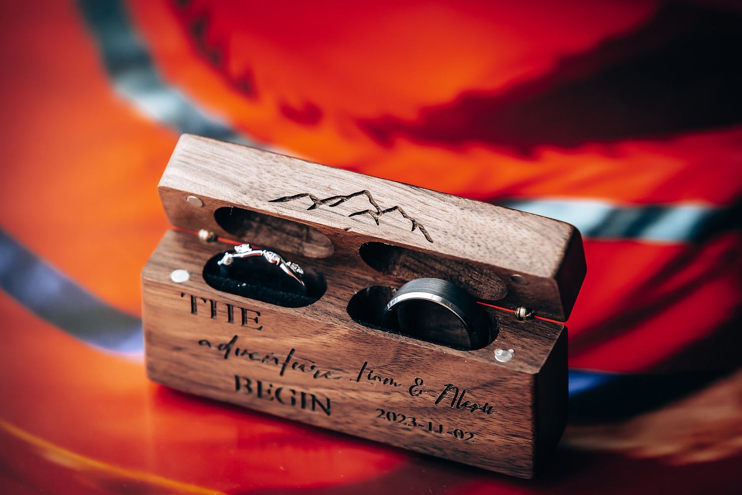 Close-up shot of a wooden kazoo musical instrument with text engraving against a red and black background.