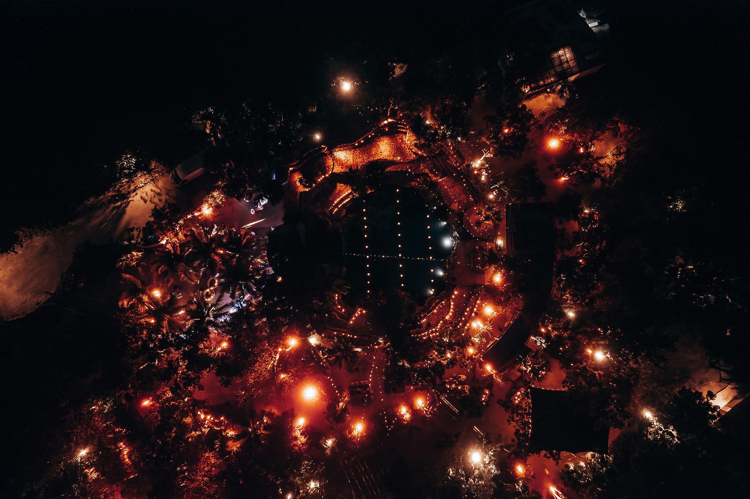 Glowing string lights create a magical atmosphere at an outdoor nighttime wedding reception.