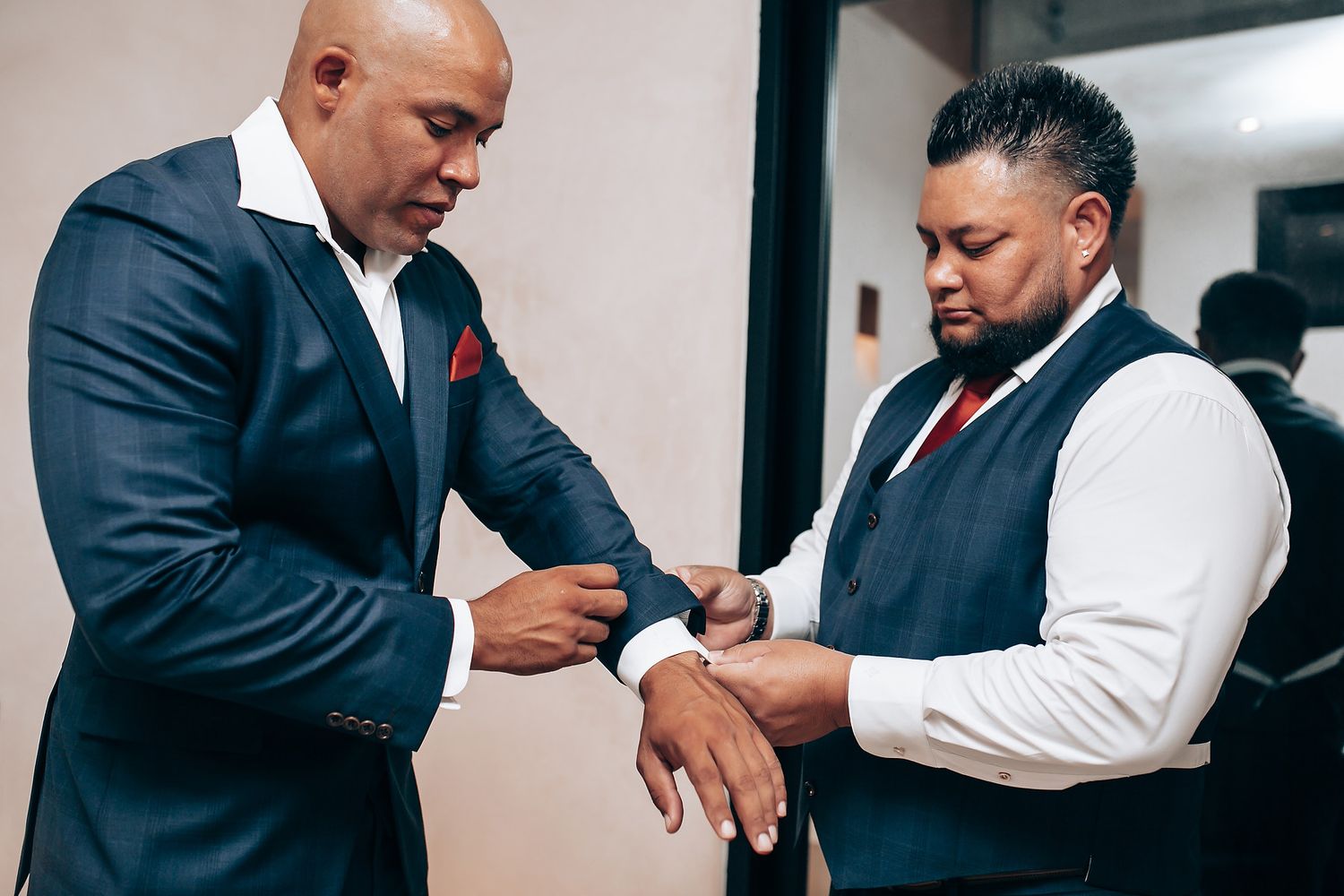 Groomsmen in formal suits preparing for a wedding ceremony.